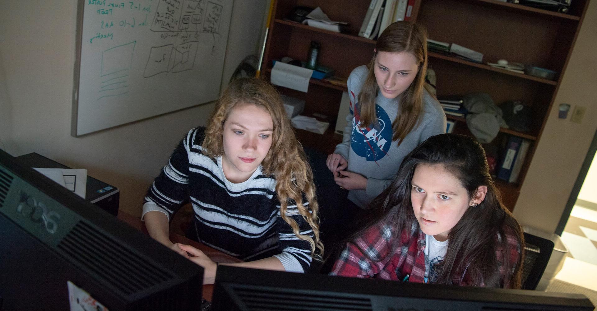 三个学生在电脑上工作